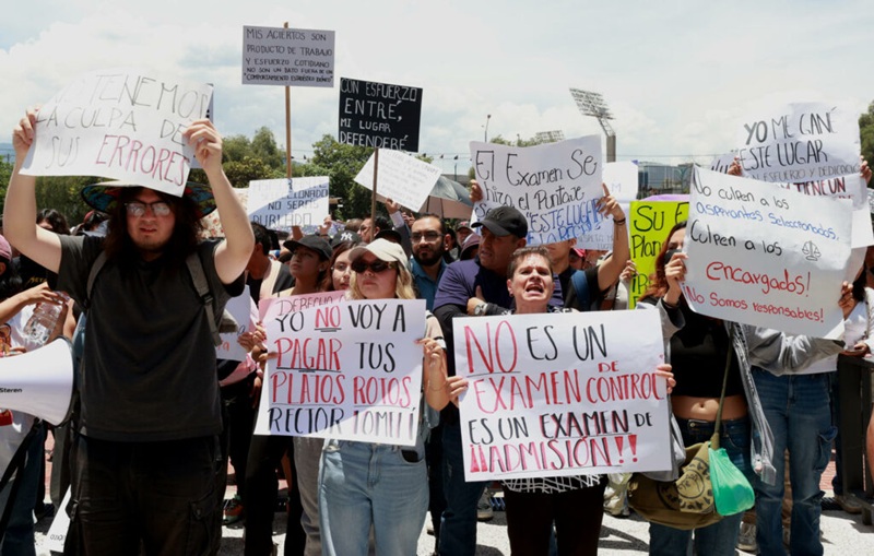 JÓVENES MUESTRAN CARTELES DURANTE UNA MANIFESTACIÓN FRENTE A LA TORRE DE RECTORÍA DE LA UNIVERSIDAD NACIONAL AUTÓNOMA DE MÉXICO (UNAM),
