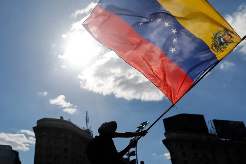 CIUDADANO VENEZOLANO ONDEA UNA BANDERA DE SU PAÍS DURANTE UNA MANIFESTACIÓN EN APOYO A LA INTERVENCIÓN DE ESTADOS UNIDOS EN VENEZUELA